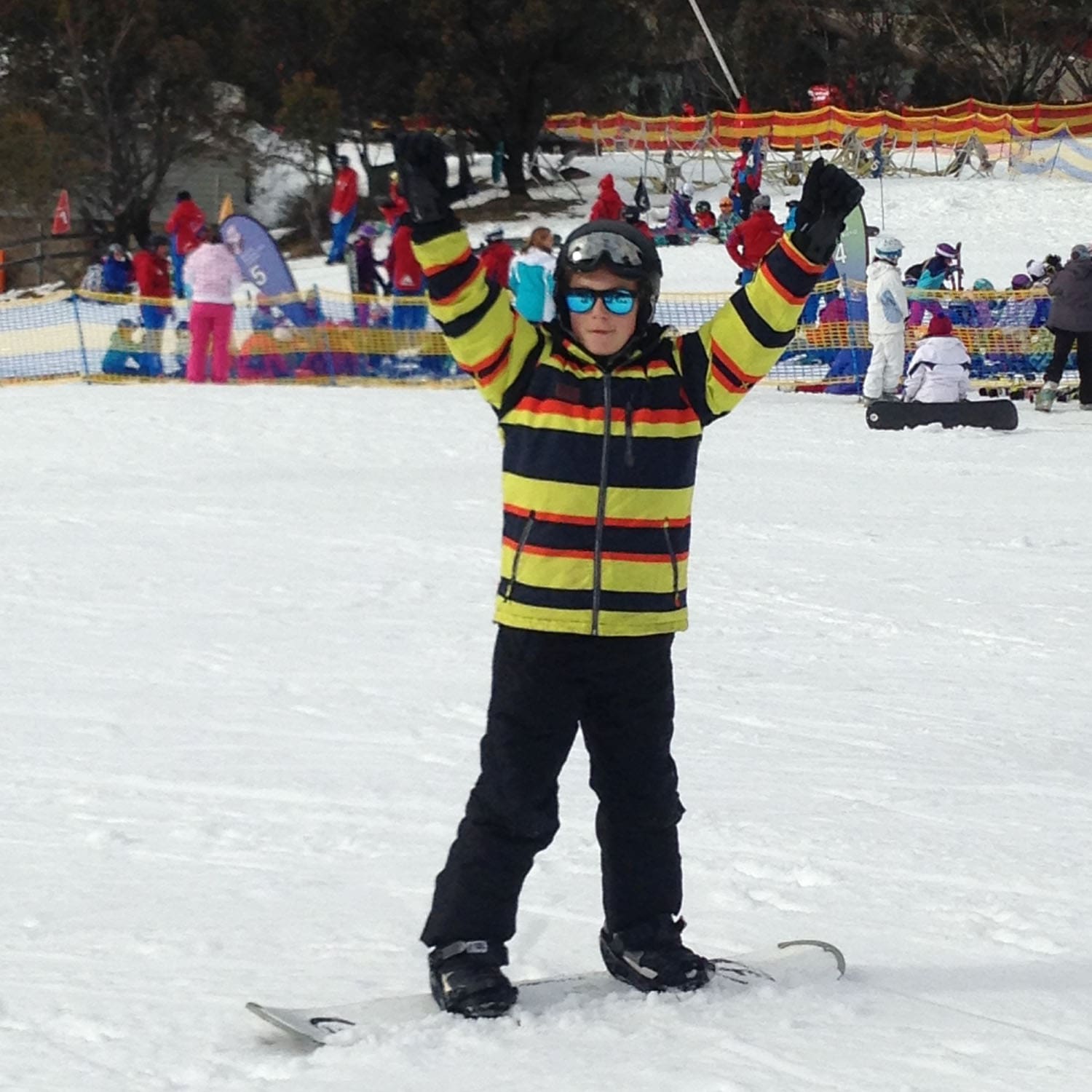 Triumphant student celebrates resilience and joy while snowboarding, embodying Kindlehill Steiner Schools commitment to adventurous outdoor education.