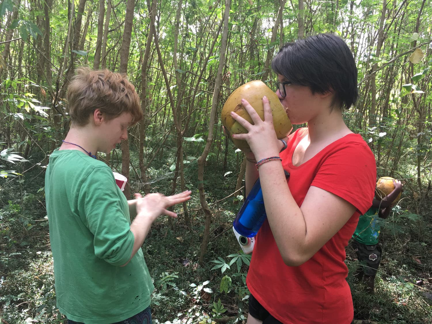 Students share fresh coconut water, honouring cultural exchange and a deep connection to the earth and community spirit.