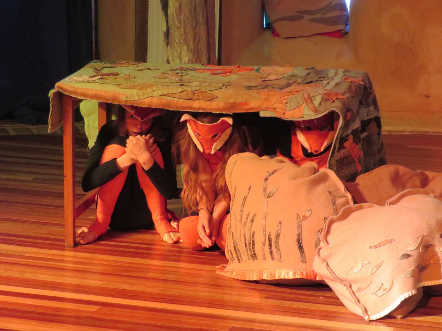 Kindlehill students in animal masks huddle together, bringing poignant stories of Country to life through artistic performance.