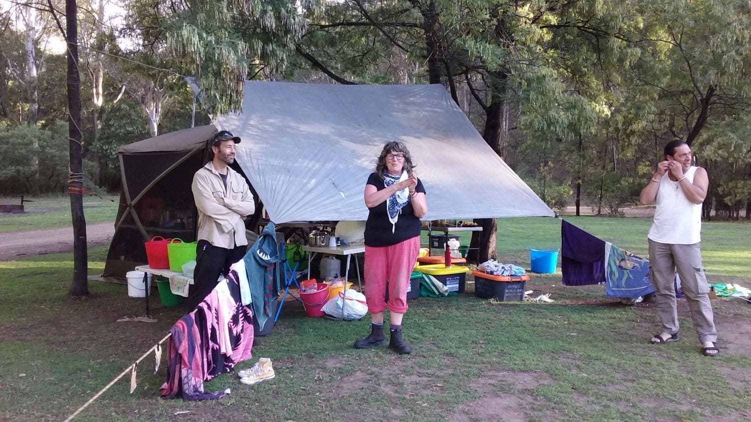 Resilient Kindlehill adults model cooperation at their campsite kitchen, fostering community spirit through shared connection with the land.
