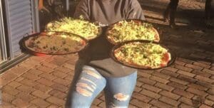 Kindlehill students share wood-fired pizzas, nourishing social connection and community spirit during a warm outdoor social gathering.