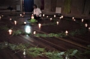 Honouring the Winter Solstice, a person lights a central candle within a sacred, spiralling greenery path.