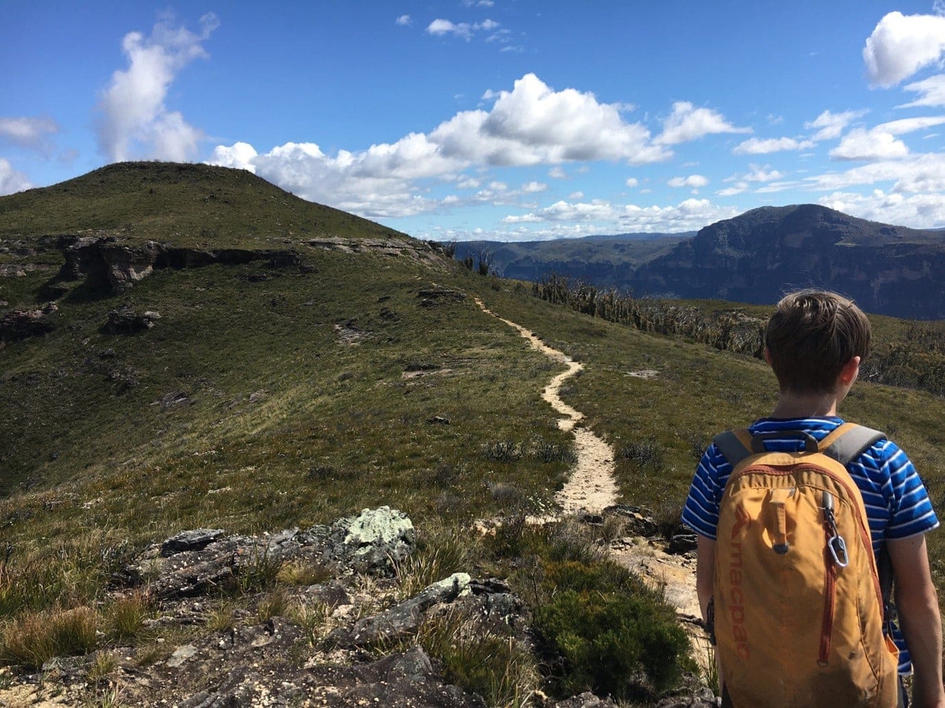 A Kindlehill student follows a winding mountain path, cultivating resilience and maturity through an independent, adventurous journey.