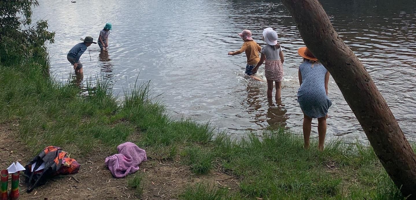 Kindlehill students wade in the lake, honouring their connection to nature and community during a rite of passage.