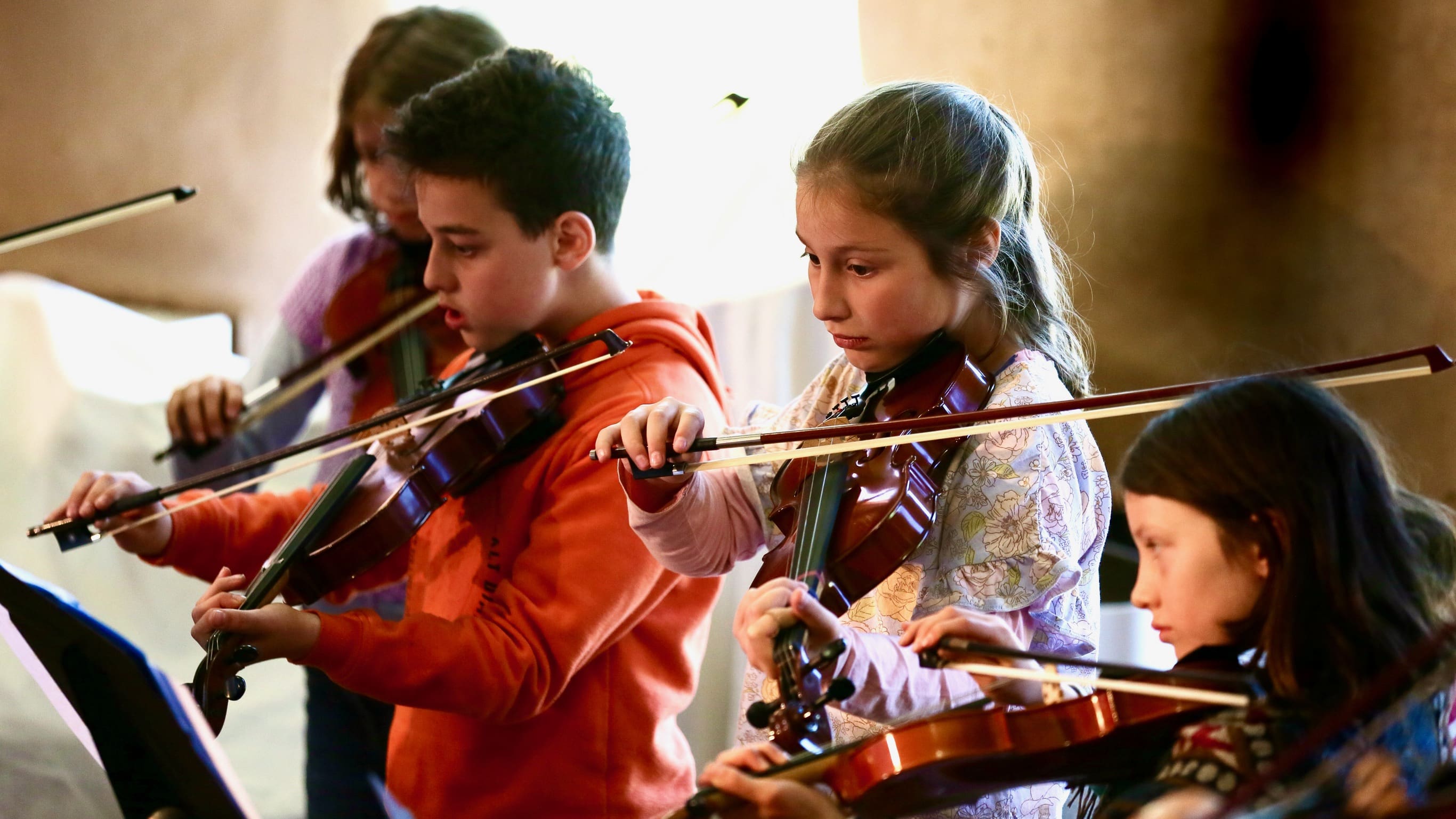 Students harmonise in a string ensemble, tuning their ears and hearts through shared musical expression and focus.