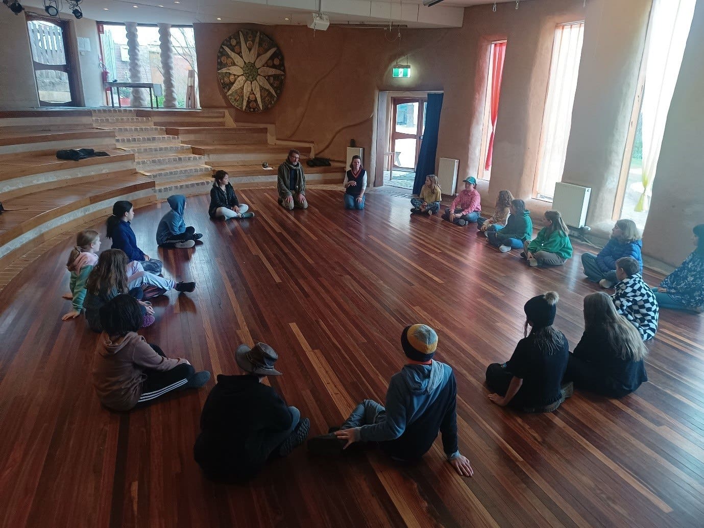 Students and visitors sit in a respectful circle, cultivating community, connection, and belonging during Kindlehill Orientation Day.