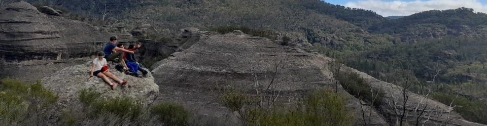 Kindlehill students sit atop ancient rock formations at Ganguddy, connecting with the wild rhythm and stories of Country.