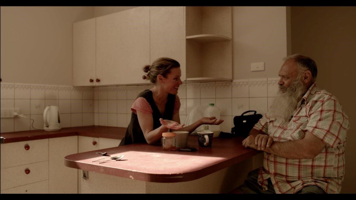Dharug Elder Uncle Colin Locke and a teacher foster healing and connection through storytelling in a kitchen setting.