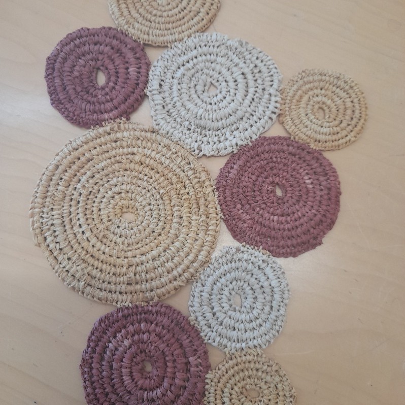 Hand-woven fibre circles represent individual identity expanding through widening circles of community, Country, and the living world.