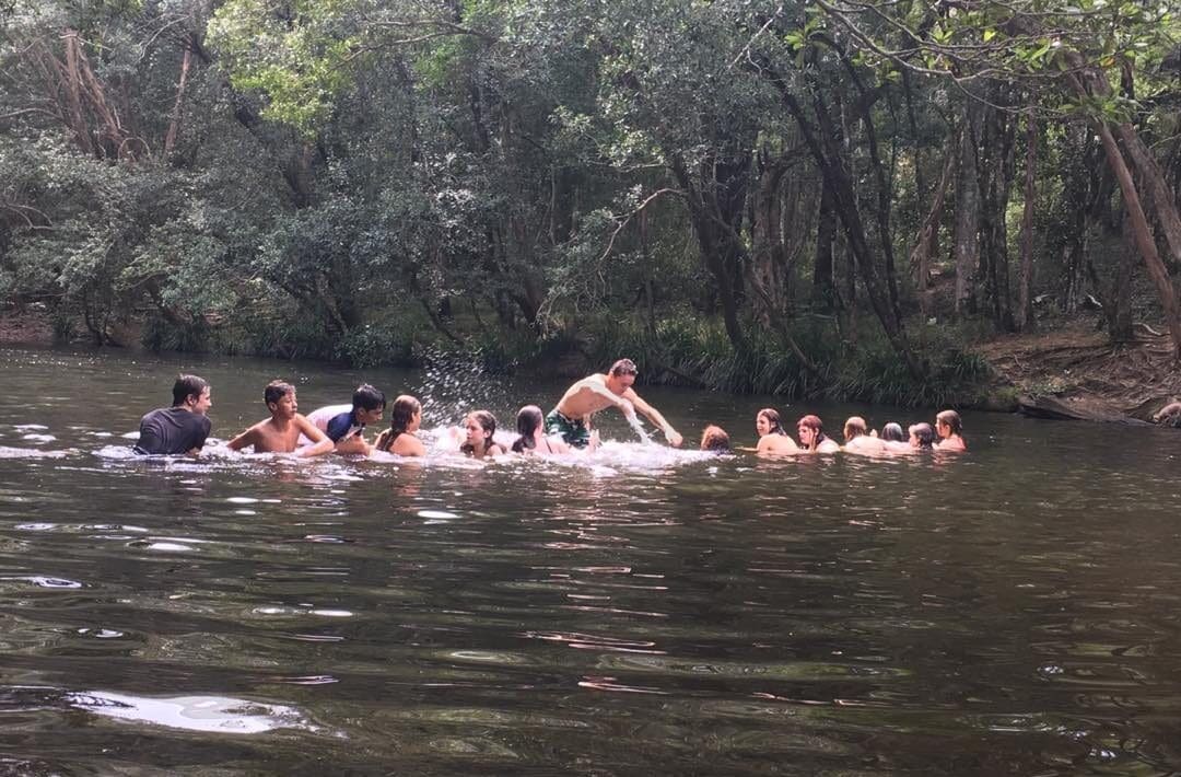 Students bond in local bushland waters, fostering community connection and an enduring appreciation for the natural world.