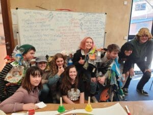 Empowered students wearing recycled materials demonstrate earth-centred social responsibility through creative action and environmental advocacy.