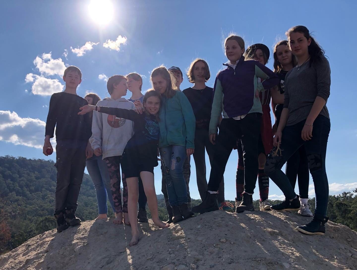 Kindlehill students stand together on a ridge, honouring their connection to land and community under the open sky.