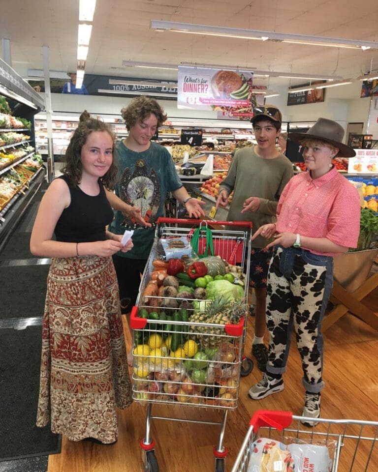 Kindlehill students select fresh produce, embodying social responsibility and community contribution through shared purpose and practical teamwork.