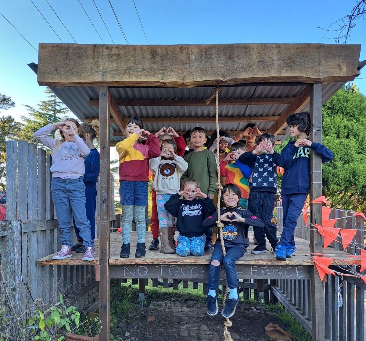 Kindlehill students form hearts, embodying a spirit of community, belonging, and deep connection within their natural environment.