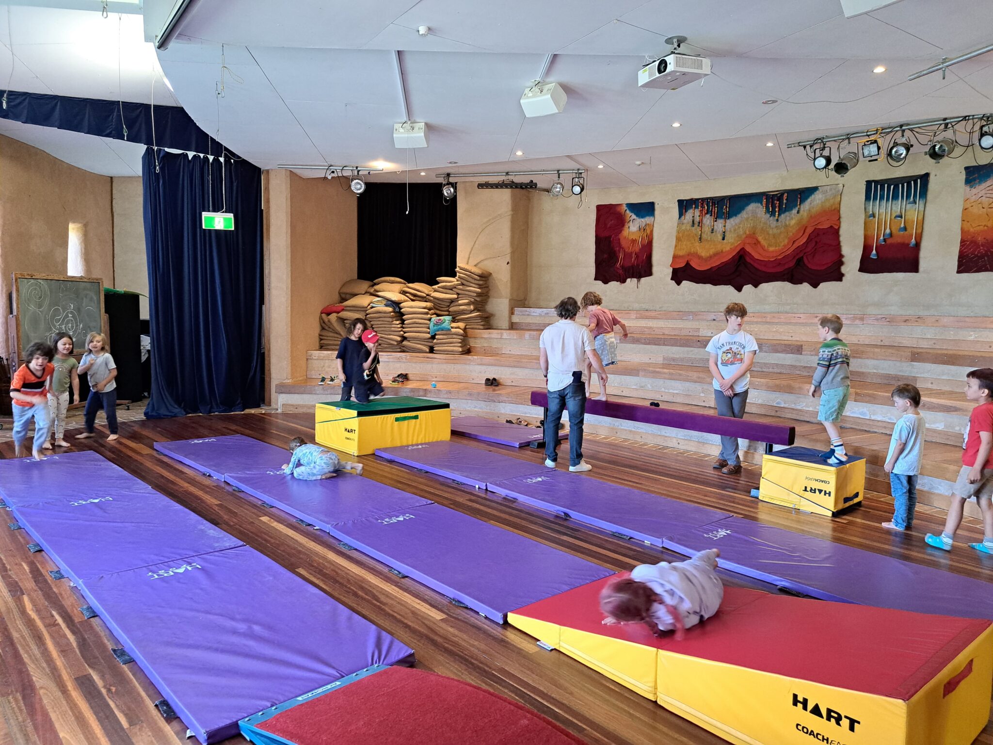 Children develop physical resilience and inner strength through joyful movement and balance within their art-filled community hall.