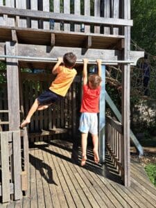 Barefoot students cultivate resilience and physical strength through adventurous play within Kindlehills natural timber environment.