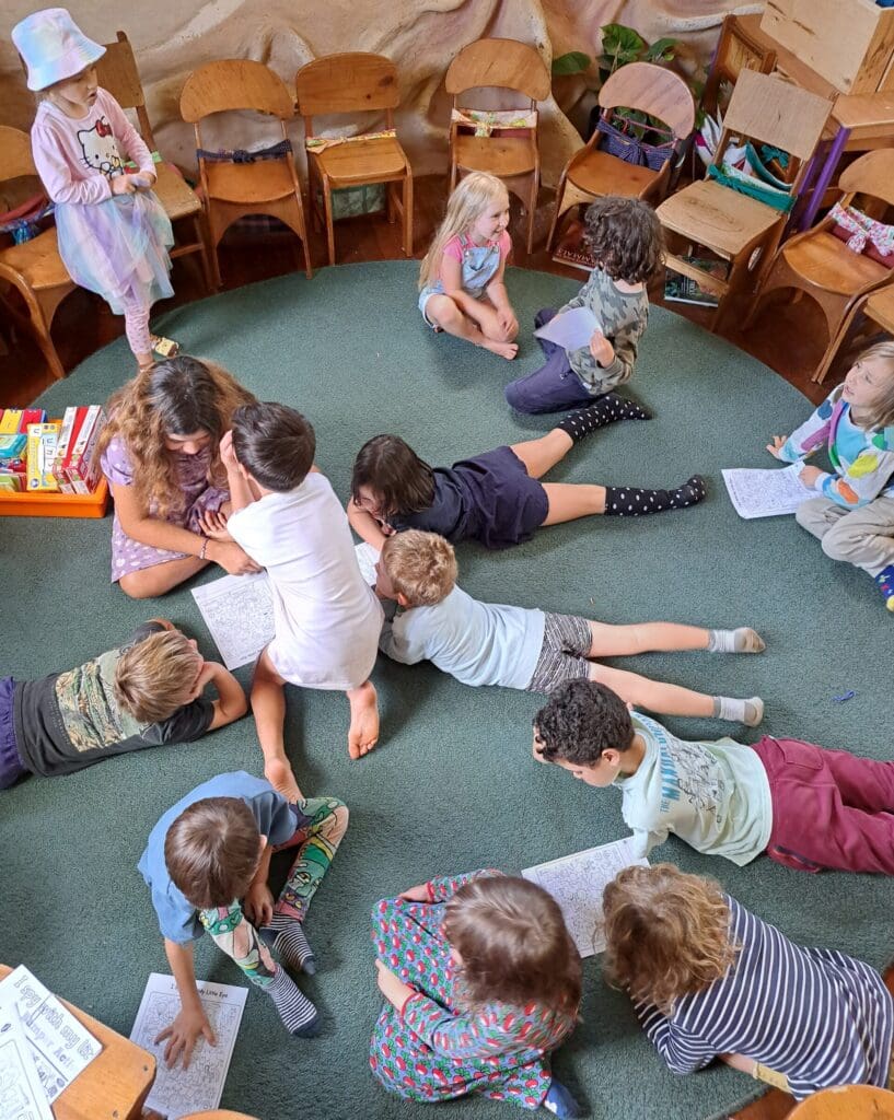 Children cluster on the classroom rug, fostering a spirit of community and shared purpose through cooperative learning.