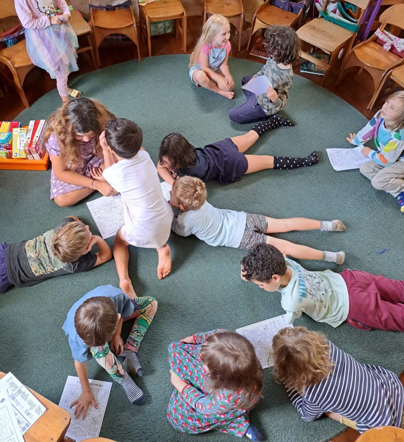 Children cluster on the classroom rug, fostering a spirit of community and shared purpose through cooperative learning.