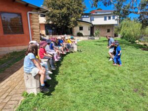 Kindlehill students gather on the grass, cultivating community spirit and connection to land through outdoor storytelling.
