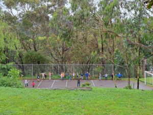 Kindlehill children stand united against the wild bushland, harmonising their community spirit with the rhythms of Country.