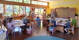 Children nurture head, heart, and hands through artistic expression within a warm, sun-drenched classroom environment at Kindlehill.