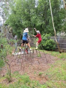 Students navigate climbing structures in the bushland, growing into whole humans through adventurous play and connection to Country.