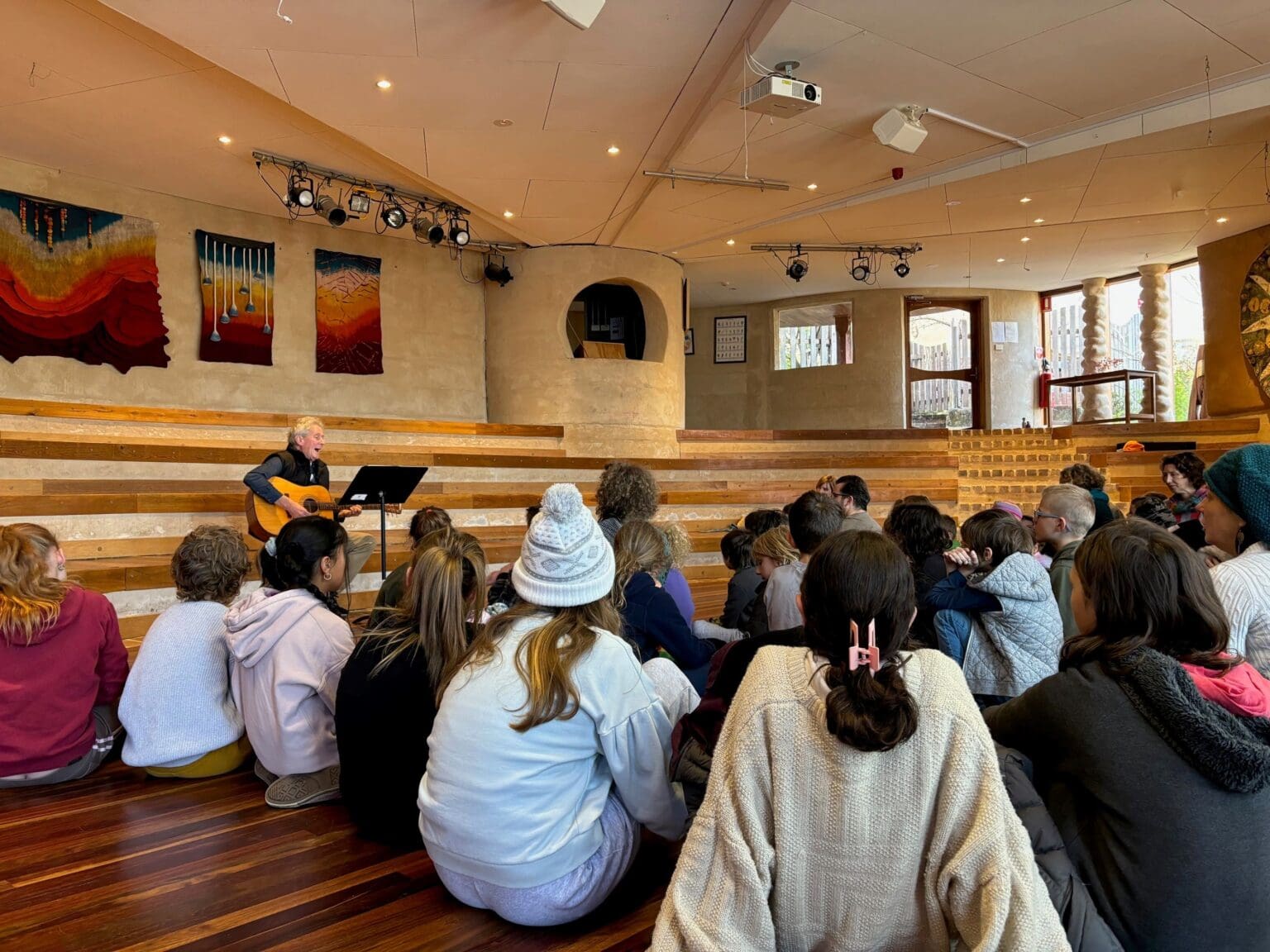 The Kindlehill community gathers for music, fostering a warm spirit of connection and belonging through shared creative rhythm.