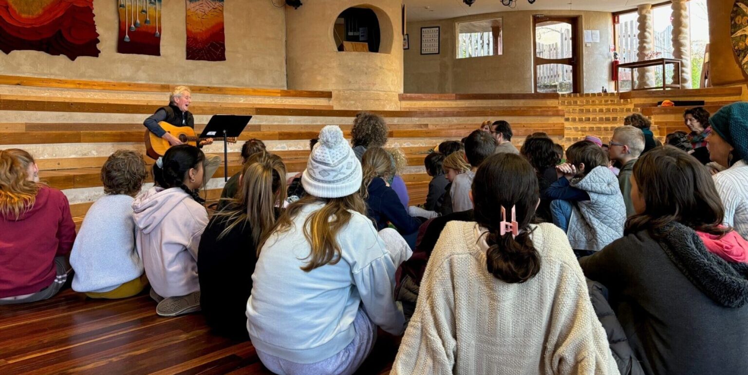 The Kindlehill community gathers for music, fostering a warm spirit of connection and belonging through shared creative rhythm.