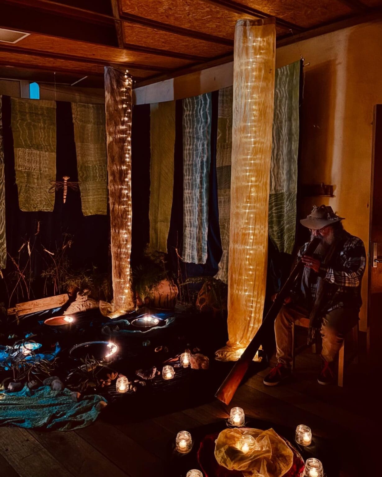 Didgeridoo song resonates in a sacred candlelit sanctuary, honouring Country and awakening a deep sense of the sacred.