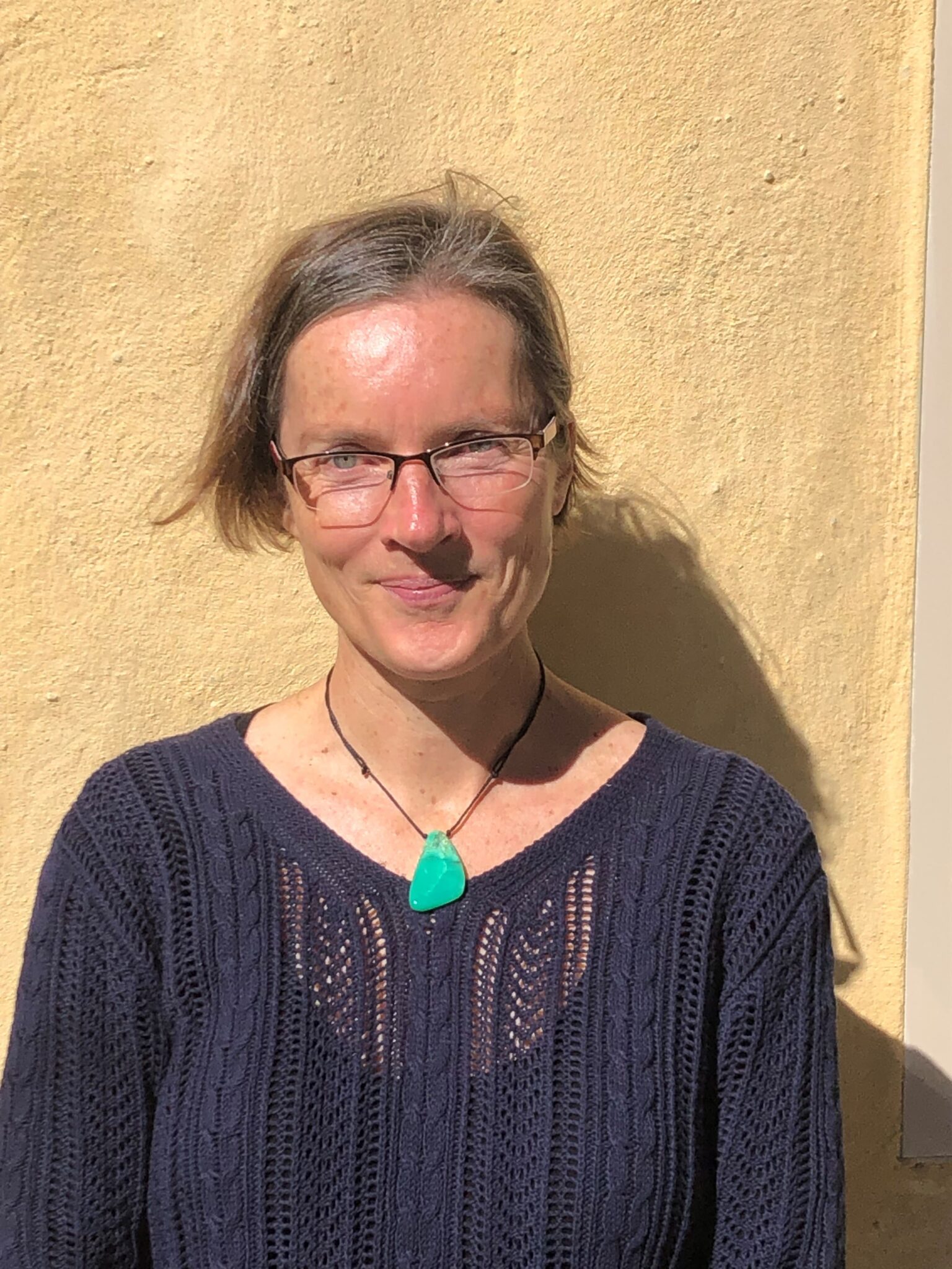 A Kindlehill educator wearing a green pendant embodies our schools grounded spirit and deep connection to nature.