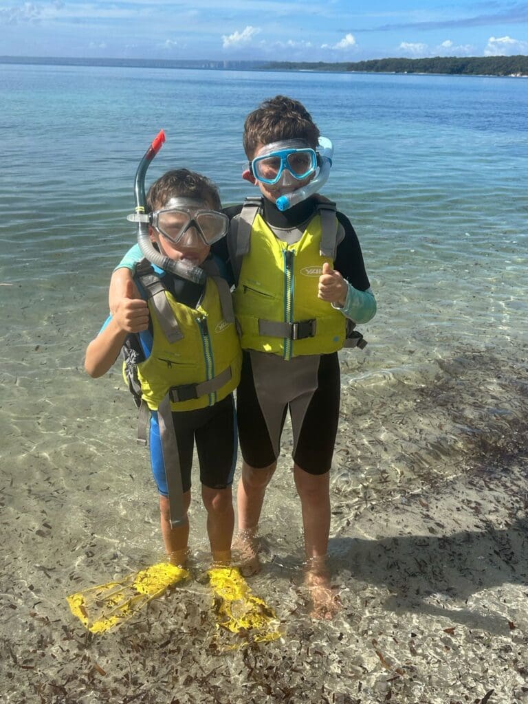 Friends in snorkelling gear foster connection and curiosity, celebrating nature through adventurous, water-based discovery in the living world.