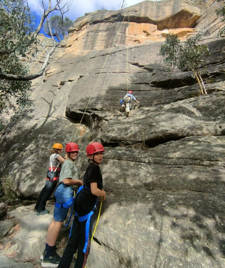Kindlehill students foster resilience and connection while scaling sandstone cliffs together in the wild Blue Mountains landscape.