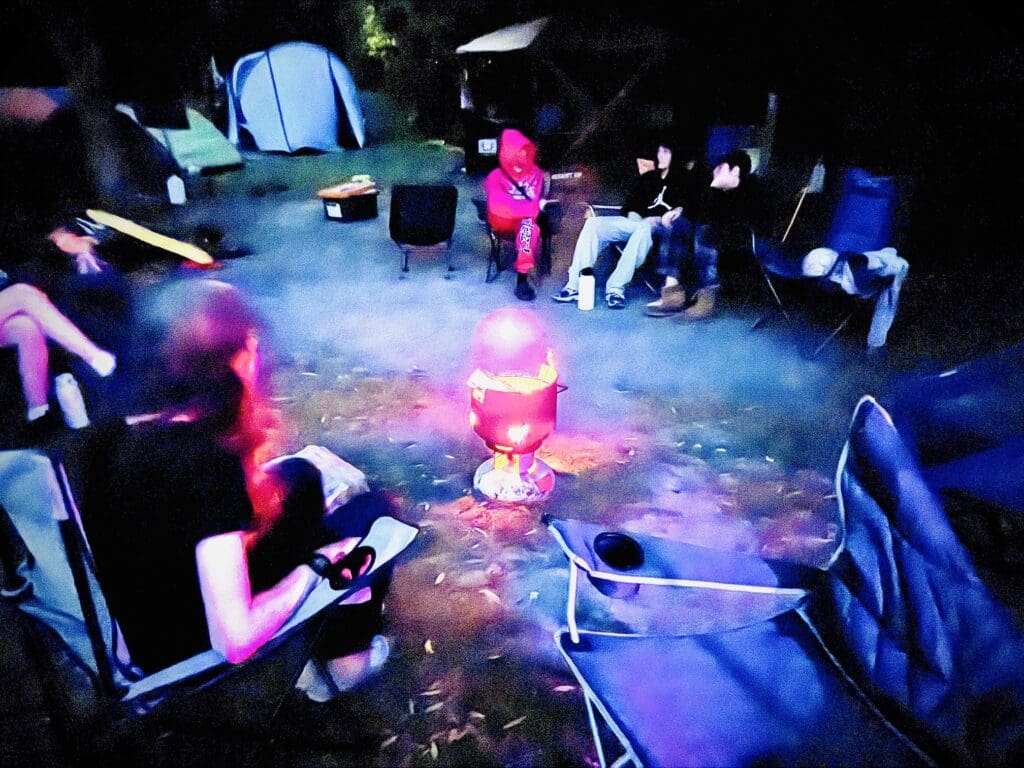 Kindlehill students share stories around a campfire, fostering community connection and resilience under the open Blue Mountains sky.