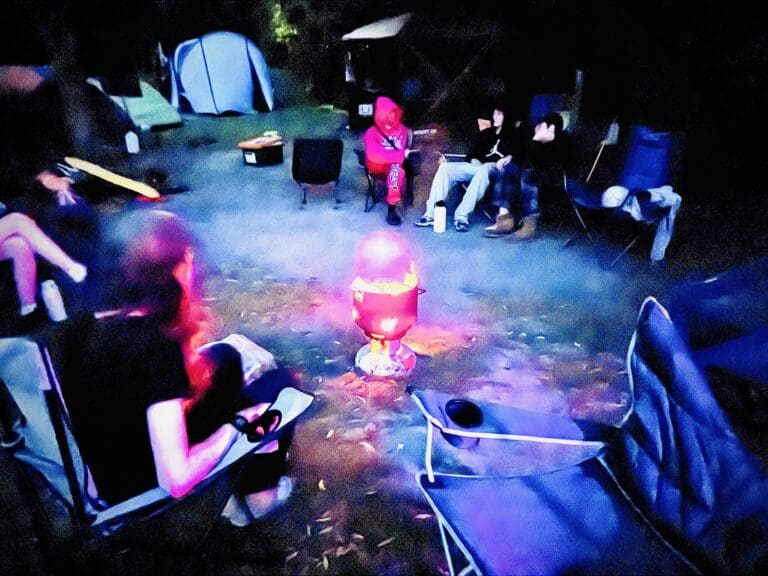 Kindlehill students share stories around a campfire, fostering community connection and resilience under the open Blue Mountains sky.