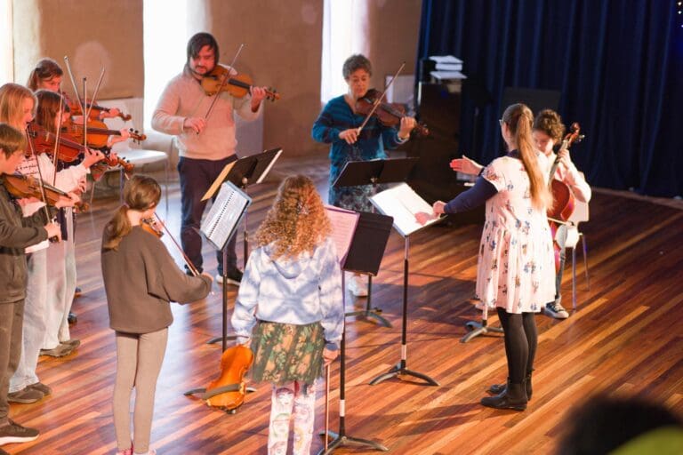 Kindlehill students and mentors play music together, illustrating the schools communal spirit and commitment to artistic expression.