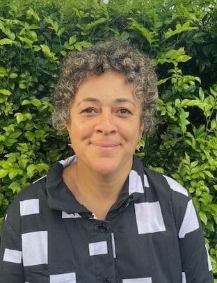 A smiling woman embodies the Kindlehill spirit of belonging and a deep, earth-centred connection to nature.