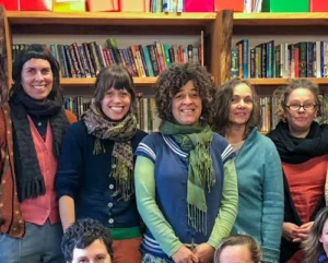 Kindlehill staff unite before bookshelves, honouring the warm spirit of community and shared commitment to cultivating whole humans.