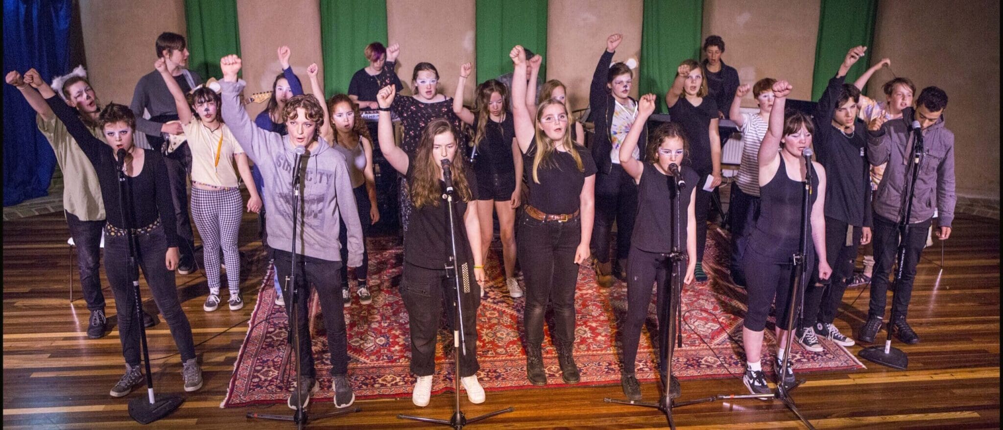 Empowered Kindlehill students raise fists and voices in unison, demonstrating their courage, shared purpose, and creative strength through performance.