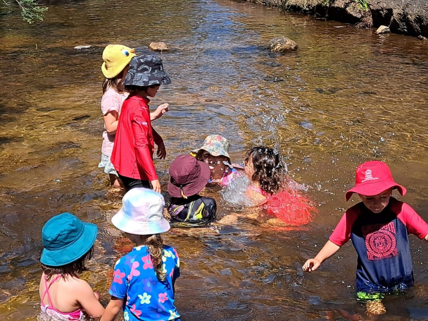 Children immerse themselves in natural waters, fostering deep connection with Country and the seasonal rhythms of the bushland.