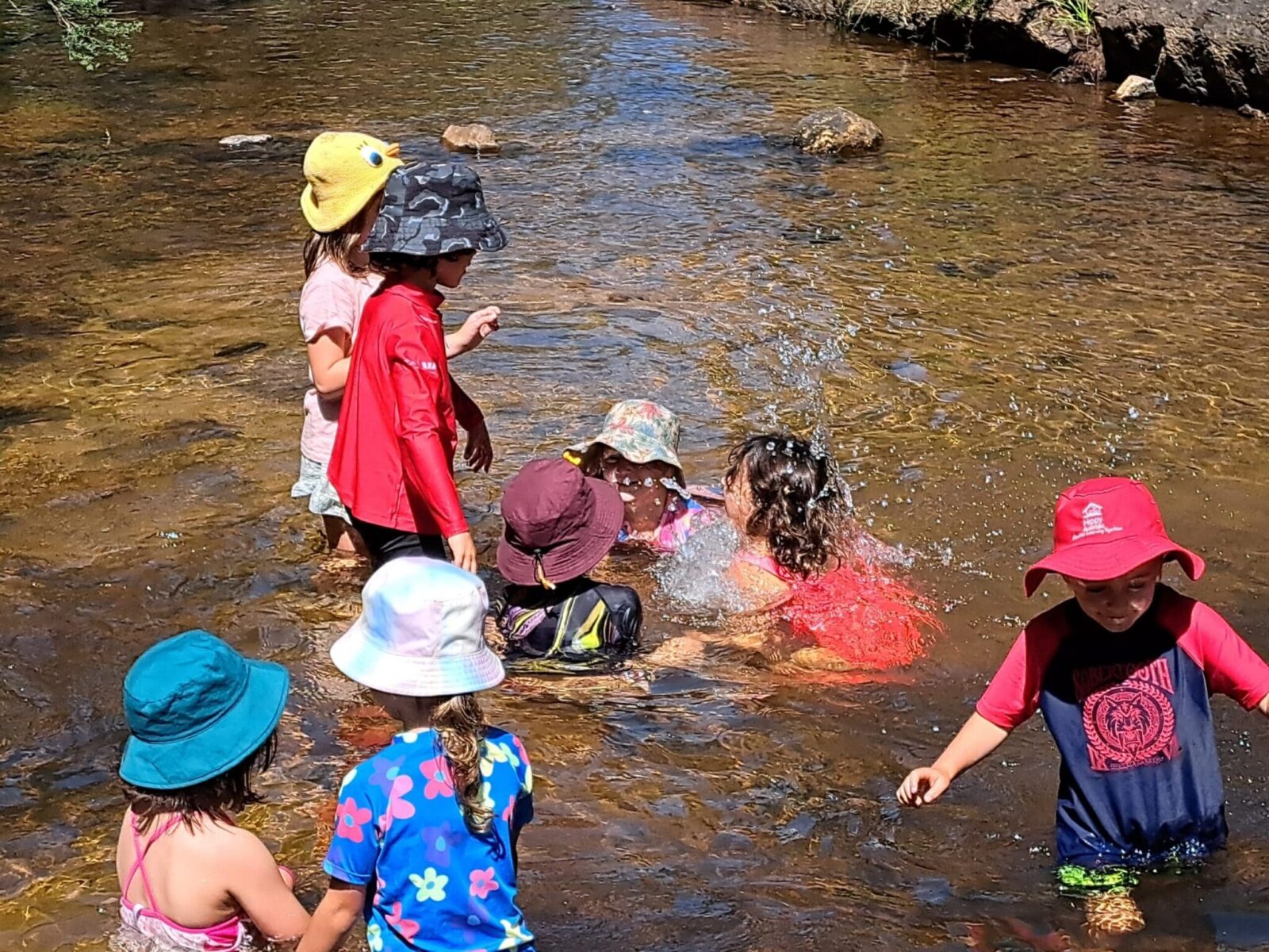 Children immerse themselves in natural waters, fostering deep connection with Country and the seasonal rhythms of the bushland.
