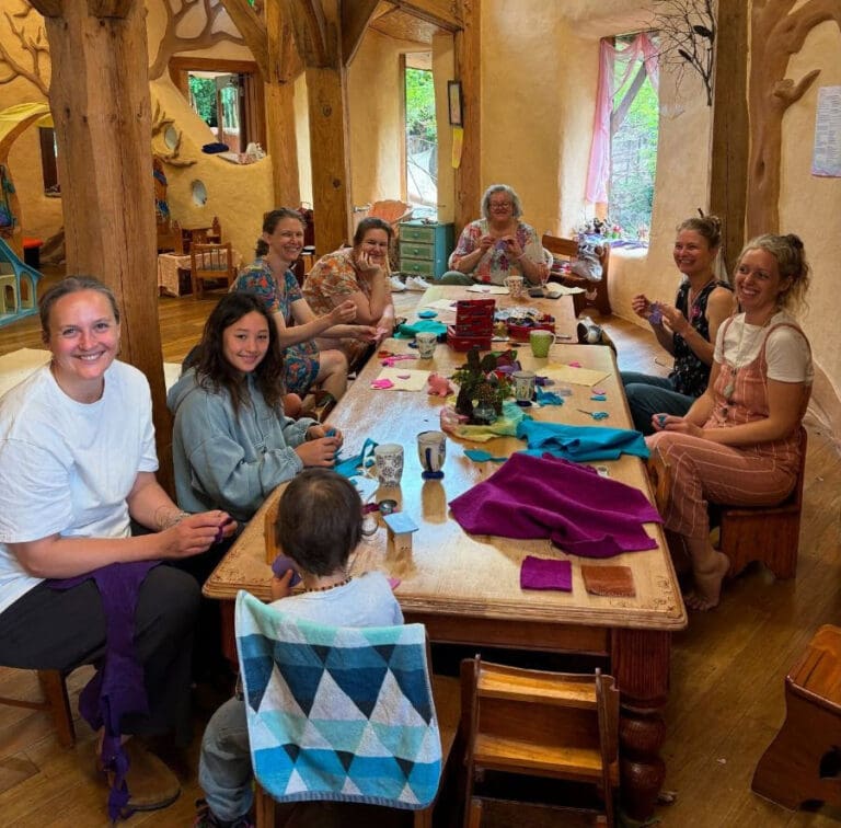 Community members craft together inside the hand-sculpted, earth-built kindergarten, honouring a shared sense of belonging and social collaboration.